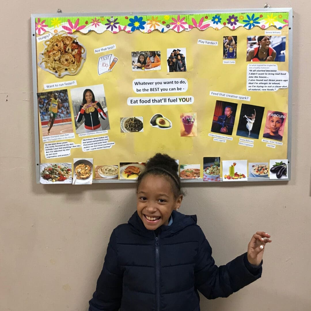 A young girl posing in front of a board